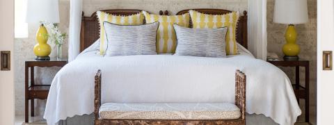 The image shows a beautifully styled bedroom with a focus on a neatly made bed