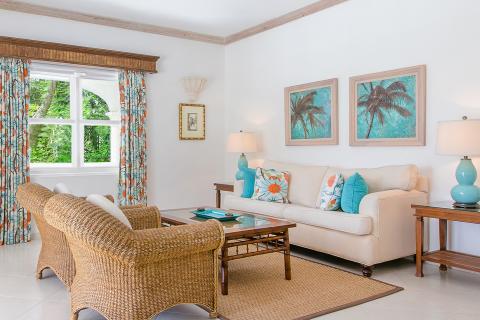 This image depicts a bright and airy living room with a tropical style decor