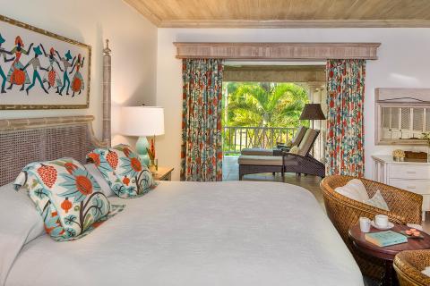 The image features a well-appointed bedroom with a tropical theme