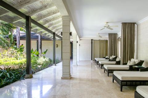 The image shows a luxurious, open lounge area, likely a part of a resort or spa