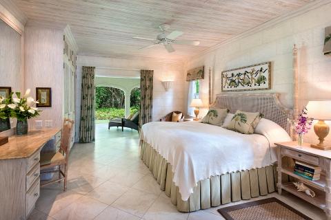 This image displays an elegantly decorated bedroom with tropical styling influences