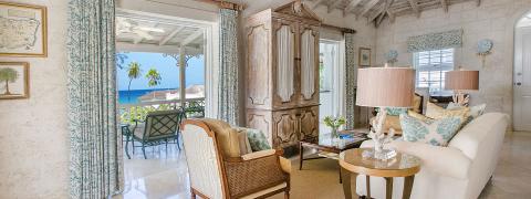 The image shows a beautifully decorated room with a beachfront view