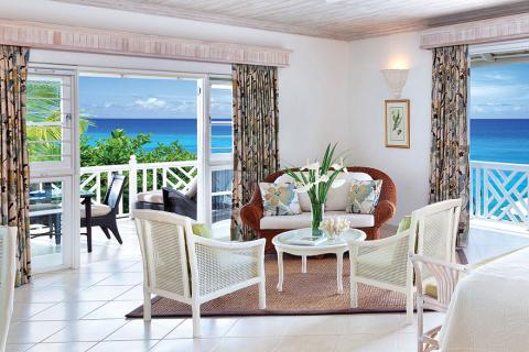 This image shows an elegantly designed tropical-style room with a serene ocean view