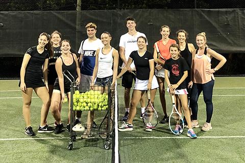 This image shows a group of people on a tennis court