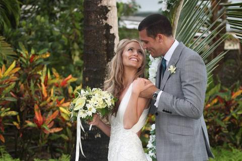 The image depicts a wedding scene featuring a bride and groom outdoors