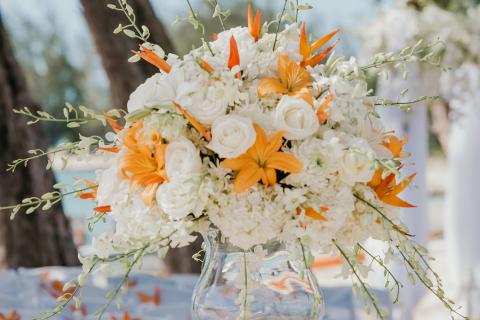 The image displays a beautifully arranged floral centerpiece in a clear glass vase