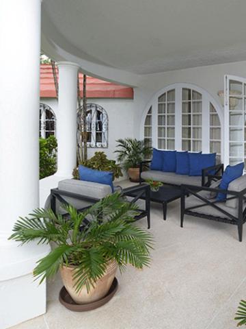 The image depicts a cozy outdoor patio area of a home