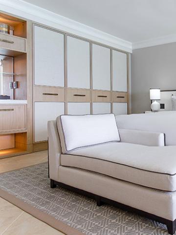 The image shows an elegant interior space that includes a modern sofa with a single white cushion on it