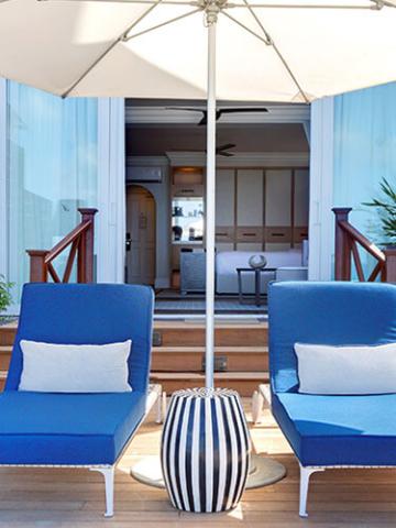 The image shows an elegant outdoor seating area on a wooden deck