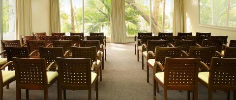 This image shows a room set up with rows of brown chairs, each featuring green seat cushions