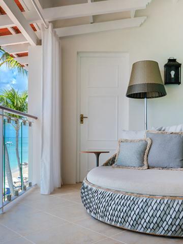 The image depicts a well-furnished room in a beachside property