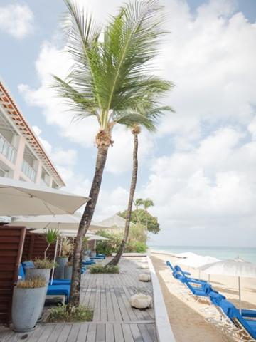 The image shows a beachside setting with a clear focus on relaxation and vacation vibes