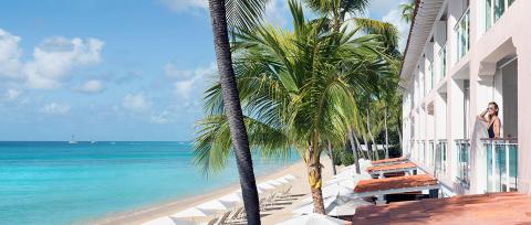 This image displays a picturesque beachfront setting with a luxurious hotel structure