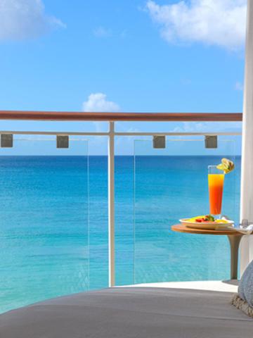 The image shows a tranquil seaside balcony view
