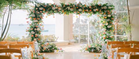 The image shows a beautifully decorated wedding venue near the beach