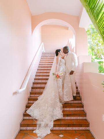 This image shows a wedding scene with a couple standing on a staircase