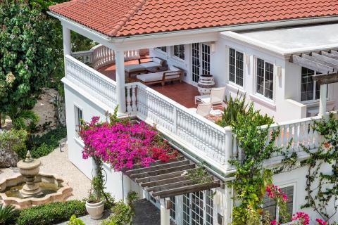 The image shows a beautifully designed outdoor area of a traditional-style house