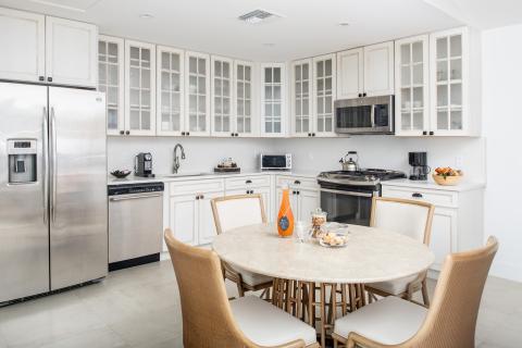 The image shows a modern, well-lit kitchen featuring various appliances and furnishings