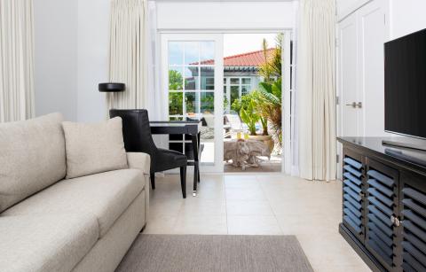 This image features a contemporary living room that opens out onto a patio
