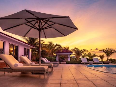 This image shows a luxurious outdoor pool area at sunset