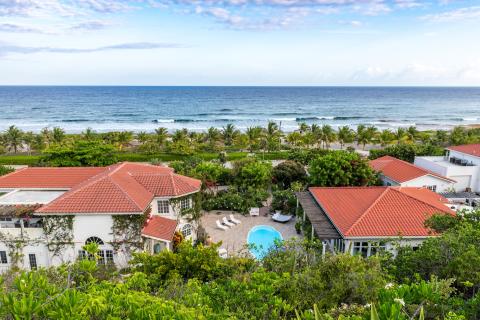 This image shows a serene coastal setting with several white buildings that have red tile roofs