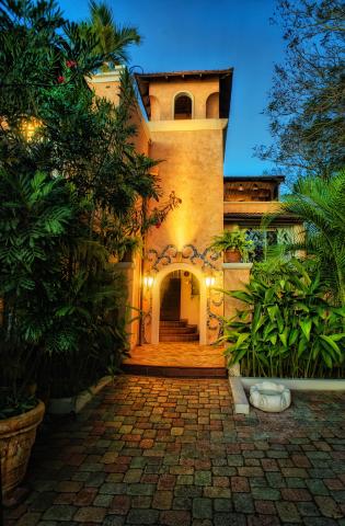 The image shows a beautifully designed house building in a warmly lit setting at dusk