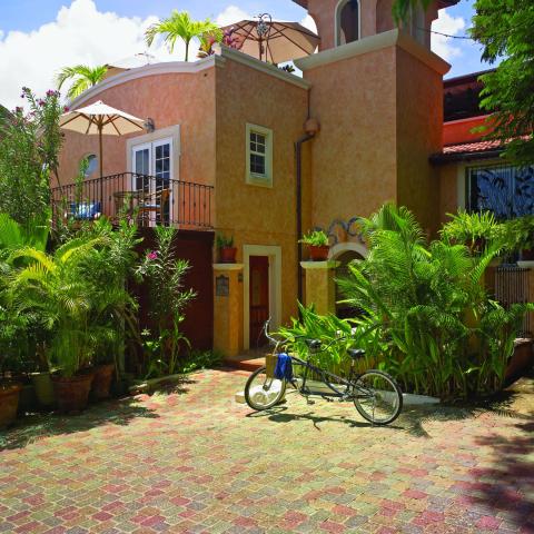 This image shows a charming courtyard in front of a peach-colored house