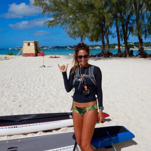 The image shows a woman on a sunny beach