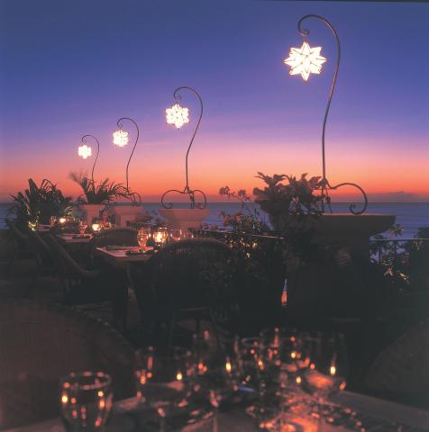 This image displays a scenic outdoor dining setting at sunset
