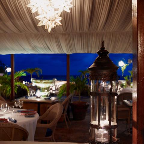 This image depicts an elegant outdoor dining setting at dusk