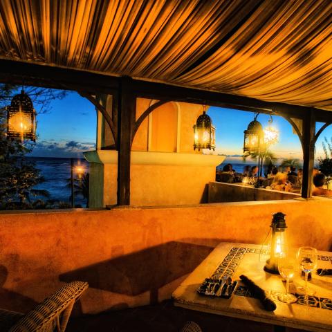 The image shows a beautiful outdoor dining setup at dusk