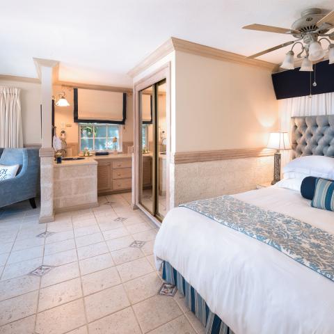 This image shows a bedroom featuring a sophisticated coastal or resort-style interior design