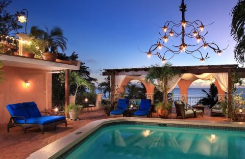 This image features a luxurious outdoor setting by the sea during twilight
