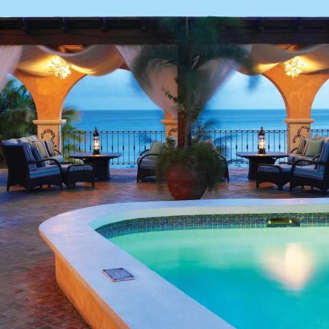 This image features a luxurious patio area overlooking the sea