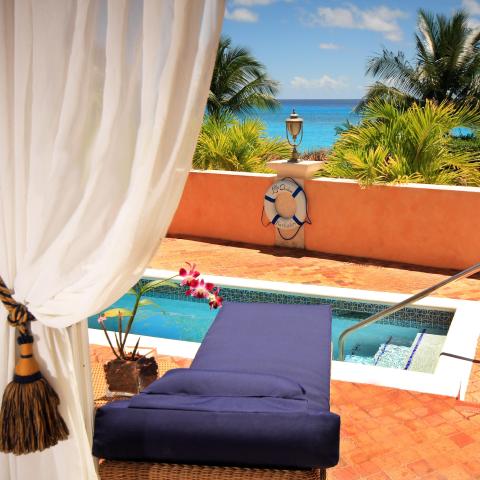 This image shows a luxurious outdoor pool area with a beautiful ocean view