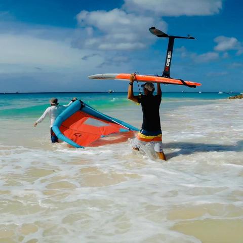This image captures two individuals at a beach engaging in water sports activities