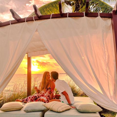 This image shows a romantic scene of a couple enjoying a sunset