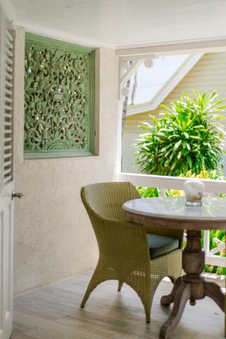 The image shows a cozy outdoor corner of a house or apartment, featuring a decorative, tranquil balcony or patio setting