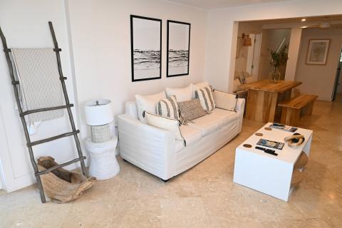 The image shows a well-decorated living room interior with a coastal or minimalist theme