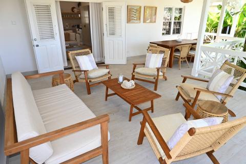 This image features a stylish, well-appointed outdoor seating area that extends into an indoor living space