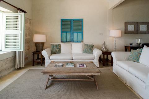 The image shows a well-decorated living room with rustic and coastal design elements