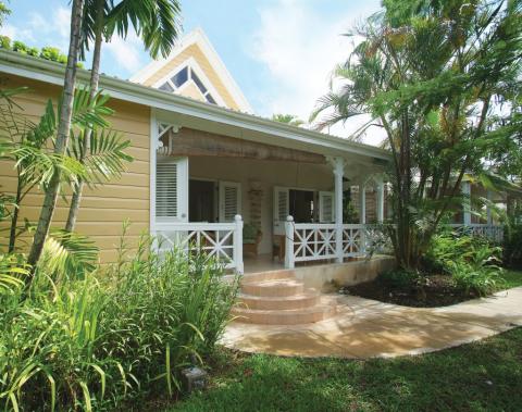 The image shows a charming, single-story yellow house with white trim