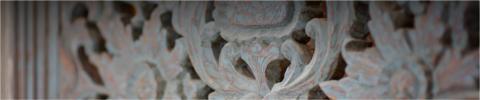 This image shows a detailed close-up of decorative wood carving, likely part of a piece of furniture or architectural element