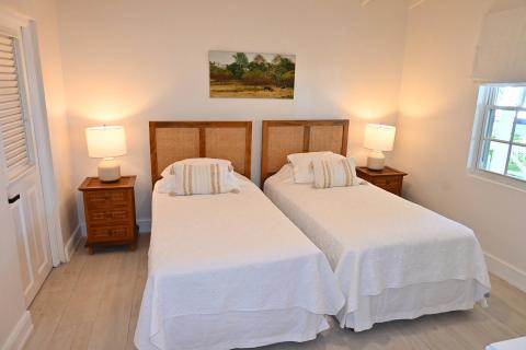 This image shows a well-lit bedroom with two single beds