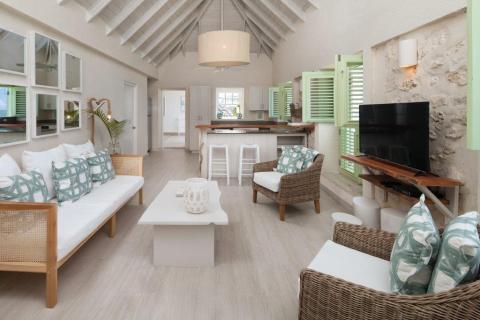 This image shows a stylishly decorated beach-style living room and kitchen
