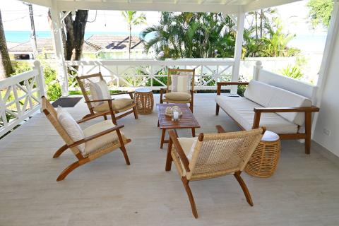 This image features an outdoor patio setting with a serene coastal view