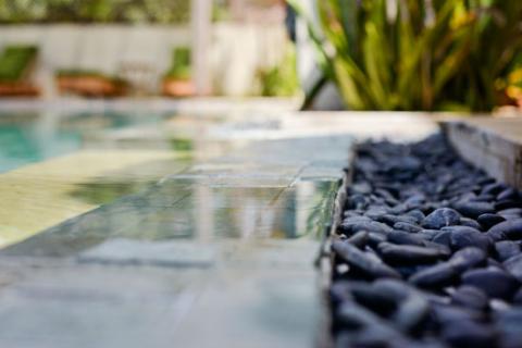 The image depicts a serene swimming pool setting