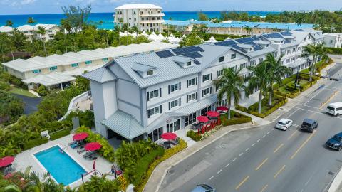 The image provides an aerial view of a coastal urban area, showcasing a mix of residential and commercial buildings