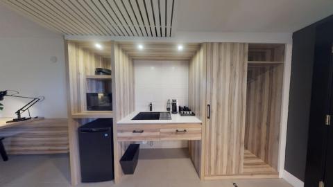 This image depicts a modern, minimalist kitchenette and a work area