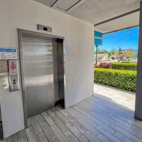 This image shows an elevator entrance located in a covered, outdoor area